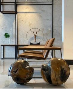 Telêmaco Borba4WOO的两个金属花瓶和一个椅子放在一个房间里