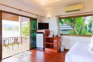 苏梅岛Lamai bayview boutique resort的一间卧室设有一张床,阳台配有电视。