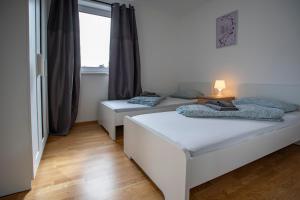 因斯布鲁克NEW East Side Apartment Innsbruck I Free Parking的带窗户的客房内的两张床