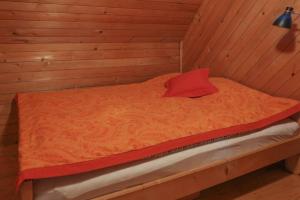 佐尔尼耶戈迪Pravlca (Fairytale Cottage)的木制房间的床,红色枕头