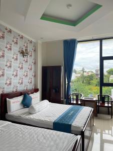 波来古市Anh Tuấn Hotel & Coffee - Pleiku, Gia Lai的一间卧室设有两张床和大窗户