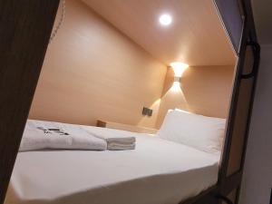 新加坡Wink at Perak Road的一间小卧室,配有白色床单