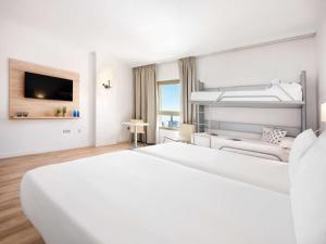 梅利利亚Hotel Melilla Puerto, Affiliated by Meliá的白色的酒店客房 - 带一张床和一张沙发