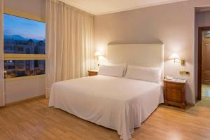 梅利利亚Hotel Melilla Puerto, Affiliated by Meliá的卧室设有白色的床和大窗户