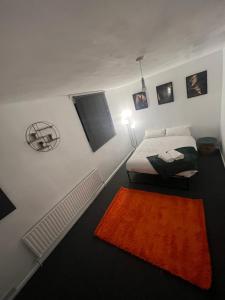 伦敦a two bedroom cosy hideaway based in greenwich的一间卧室配有一张床和橙色地毯