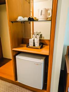 Ban Ru Sa Mi Laeโรงแรม ซี.เอส. ปัตตานี的带架子的厨房里的小冰箱