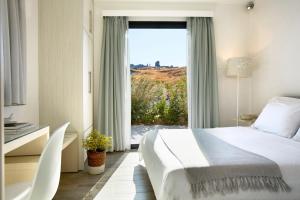 帕特雷Eleia Seafront Rooms & Villas的一间卧室设有一张床和一个大窗户