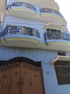 AyodhyaShri Niwas Homestay的一座带大木门和阳台的建筑