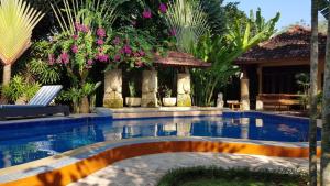 MontongbuwohLombok Stanley Garden Villas的鲜花庭院中的游泳池