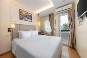 河内黄金传奇钻石酒店 的卧室设有一张白色大床和一扇窗户。
