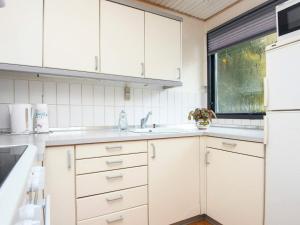 锡尔克堡4 person holiday home in Silkeborg的厨房配有白色橱柜和水槽
