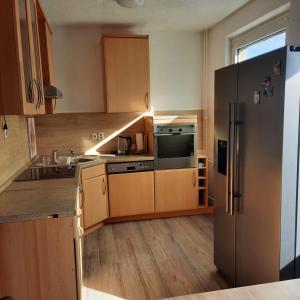 新勃兰登堡NB Hochschule Zwei Zimmer Wohnung的厨房配有木制橱柜和不锈钢冰箱。