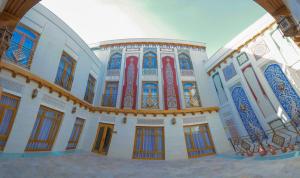 布哈拉Antique hotel Imran的一座带五颜六色的窗户和门的大型建筑