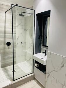 德班Pavilion Hotel Durban的带淋浴和盥洗盆的浴室
