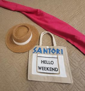 岘港Santori Villa My Khe Beach的草帽和装有你好周末标志的袋子