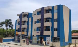 伊塔波阿Residencial Oceano Azul的蓝白色的建筑,棕榈树