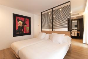 索里亚Hotel Cortabitarte的卧室配有一张白色床,墙上挂有绘画作品