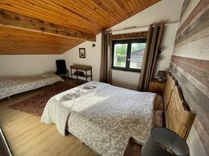 Rhodesjolie maison de campagne à 100 m de l'étang的一间卧室设有两张床和窗户。