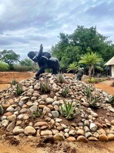 Karongwe Game ReserveKarongwe Portfolio - Chisomo Safari Camp的骑大象在一堆岩石上的人的雕像