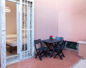 罗马Residence San Paolo的一个带粉红色墙壁的庭院里的桌椅