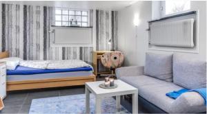 马尔默Cosy stay in southern Malmo的一间卧室配有一张床、一张沙发和一张桌子