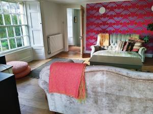洛斯特威希尔The Shire House的带沙发和红色墙壁的客厅