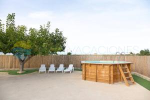 代尔特布雷Illa - Casa rural aislada con piscina y cerca playa de la Marquesa -Deltavacaciones的后院设有围栏,配有桌椅