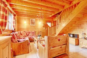 克松吕-隆日梅Le Chalet des Cœurs - Avec vue montagne的小木屋客厅配有沙发和楼梯