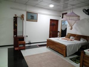 锡吉里亚sigiriya village hostel的一间设有一张床铺的卧室,位于一个带镜子的房间