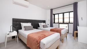 维拉摩拉Vilamoura - Spacious with Swimming Pool & View的酒店客房设有两张床和窗户。