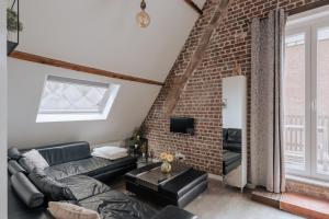 伊普尔Amazing 2 ROOMS design apartement Loft的带沙发和砖墙的客厅