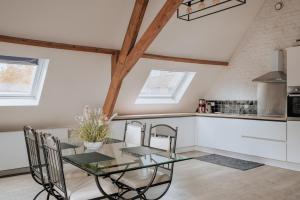 伊普尔Amazing 2 ROOMS design apartement Loft的厨房以及带玻璃桌和椅子的用餐室