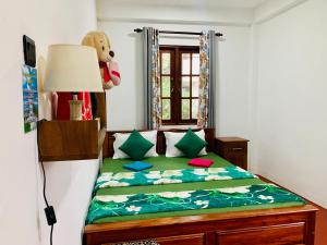 加姆波勒Ambuluwawa View Inn的一间卧室配有一张带泰迪熊的床和窗户