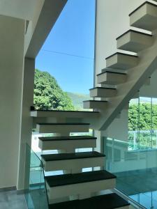 米格尔-佩雷拉Casa de vidro com vista para a Mata Atlântica no Centro de Miguel Pereira的建筑中带有窗户的楼梯