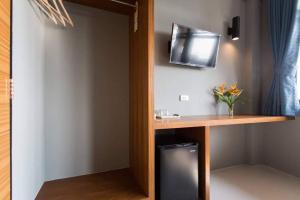 甲米镇Leisure Hostel的客房设有书桌和墙上的电视。