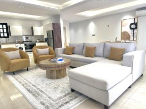 利雅德Luxurious 3 Bedroom Apartment - 5 minutes to Boulevard的客厅配有沙发、椅子和桌子