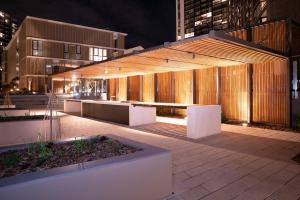 悉尼Modern 2 Bedroom Apartment Darling Square的一座在晚上在城市中建有凉亭的建筑
