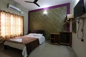 卡尔佩特塔Wayanad regal residency的一间卧室设有一张床、一台电视和一个窗口。