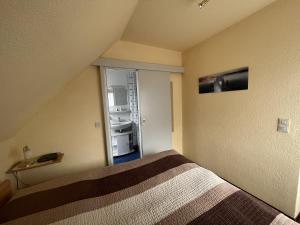 宁多夫STOE 14a Gästehaus Iden, App 3的一间卧室配有一张床,一扇门通往冰箱
