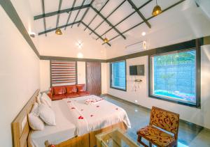 瓦亚纳德Wildside Jungle Retreat Wayanad Resort by VOYE HOMES的一间卧室配有一张床和一把椅子
