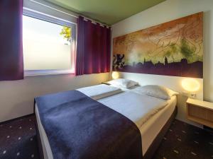 魏玛威玛住宿加早餐旅馆的一间卧室设有一张大床和一个大窗户
