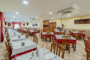 PereiroHotel Restaurante Cazador的用餐室配有白色的桌子和木椅