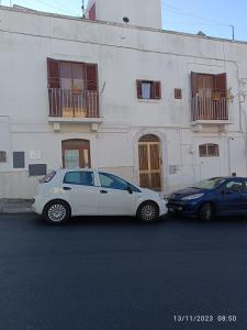 诺奇Locazione turistica La vecchia arcata的两辆汽车停在白色建筑前面