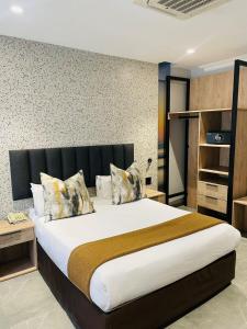 德班Pavilion Hotel Durban的一间卧室配有一张大床和黑色床头板