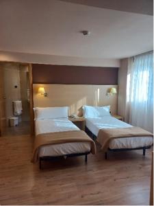 奥尼亚特Iraipe Santuario de Arantzazu Hotel的一间酒店客房内设有两张床的房间