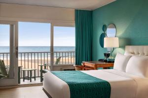 大洋城大洋城海滩豪生大酒店的一间卧室设有一张床和一个海景阳台