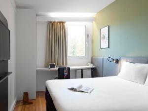 旺德夫尔莱南锡南锡-布哈布瓦宜必思酒店的酒店客房,配有一张床铺,上面有一本书