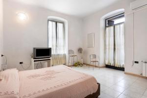 斯培西亚Cà di Mimmo的一间白色卧室,配有床和电视