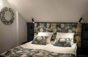 塔尔努夫Apartamenty Willa na Wzgórzu的一间卧室配有一张带花卉床头板和枕头的床。