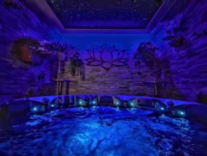 坎特伯雷Hambrook House Canterbury - NEW luxury guest house with ESPA Spa complex的紫色灯房内的热水浴池
